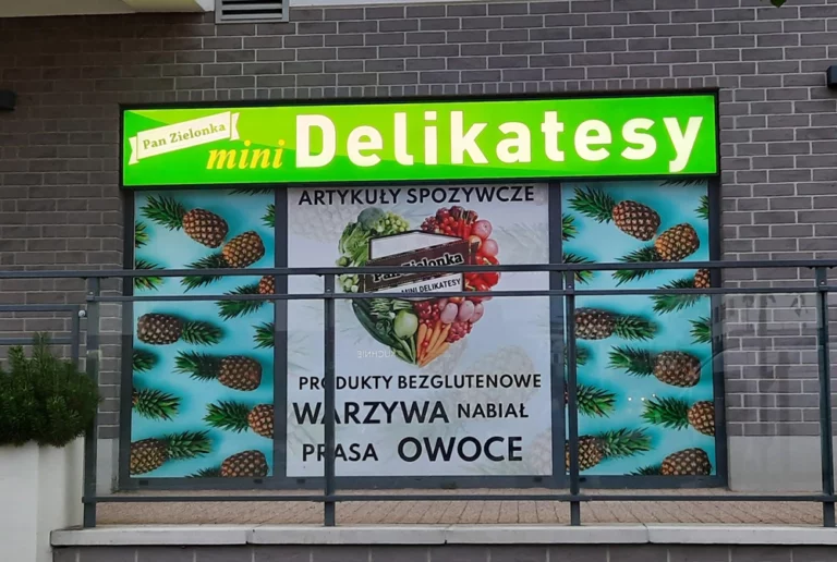 Zielony wąski kaseton aluminiowy ramowy z frontem z pleksi i białą grafiką delikatesy. Kasetony warszawa