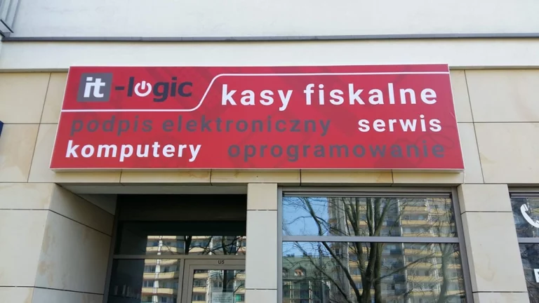 Duży czerwony kaseton z napinanym licem nad wejściem do salonu firmy topik