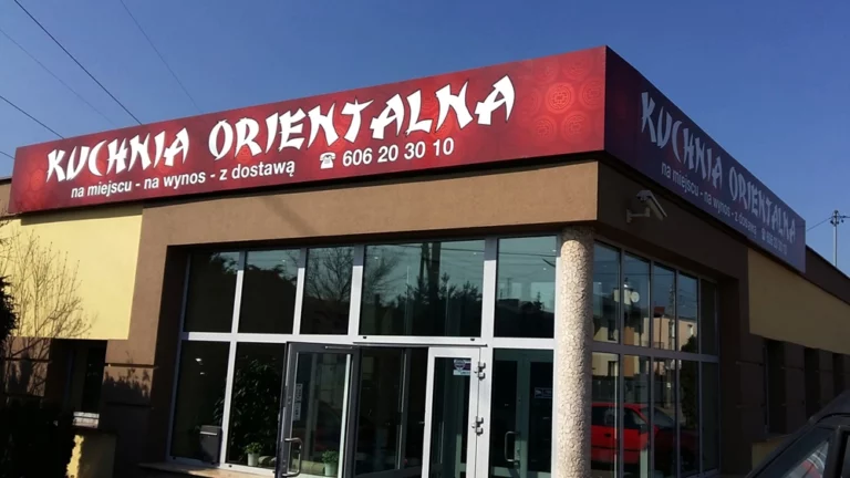 Czerwony matowy kaseton z napisem kuchnia orientalna białą grafiką