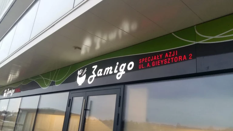 Otok z frezowanego dibondu z kolorową grafiką i białymi literami nad restauracją jamigo. kasetony z dibondu warszawa