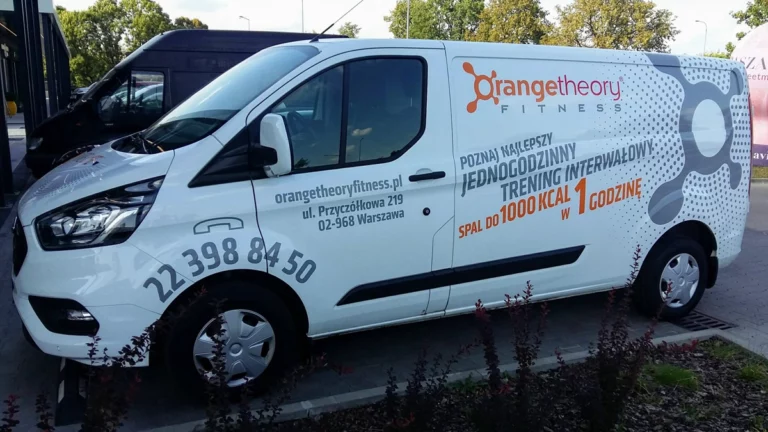 Biały samochód Ford Transit z oklejaniem korporacyjnym dla firmy Orange theory fitness. oklejanie aut warszawa