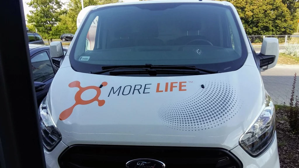 Biały samochód Ford Transit z oklejaniem korporacyjnym dla firmy Orange theory fitness