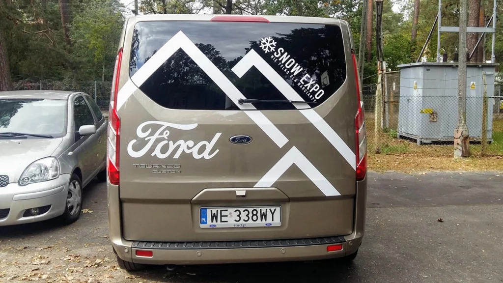 Grafika reklamowa naklejona na szarym samochodzie Ford Transit, tył. oklejanie aut warszawa