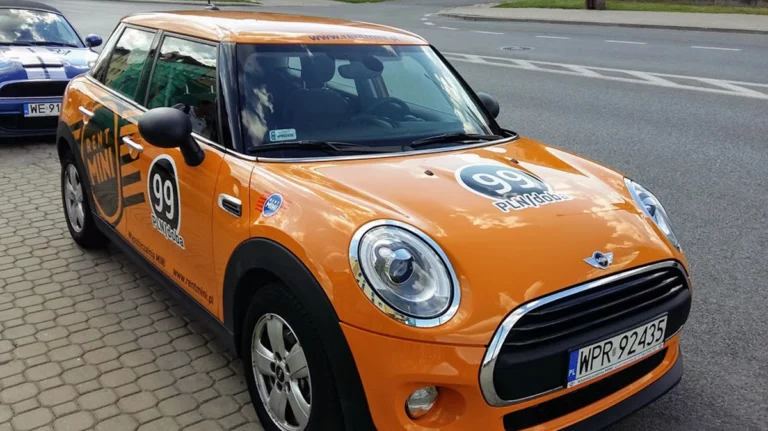 Samochód mini pomarańczowy oklejony dla firmy rent mini. oklejanie aut warszawa