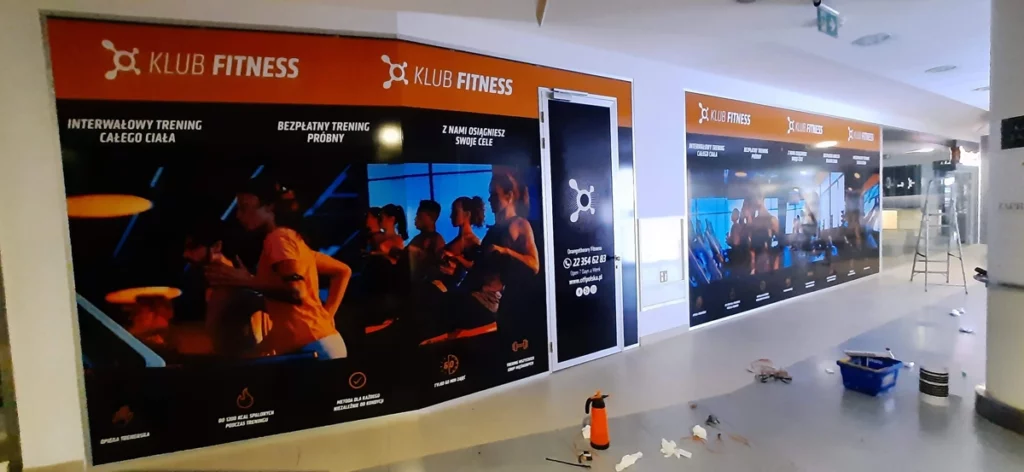 Witryny salonu Orange Theory Fitness z folią promocyjną. Oklejanie witryn Warszawa